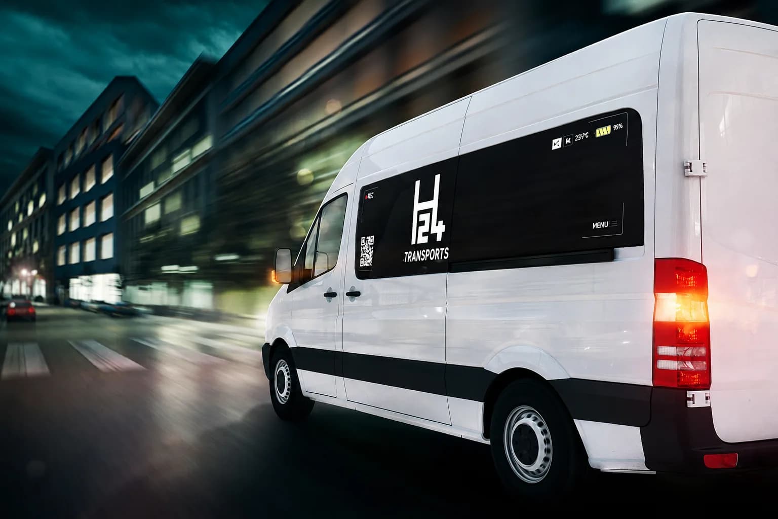 Fourgon H24 Transports en course dans une rue de ville, à la tombée du jour