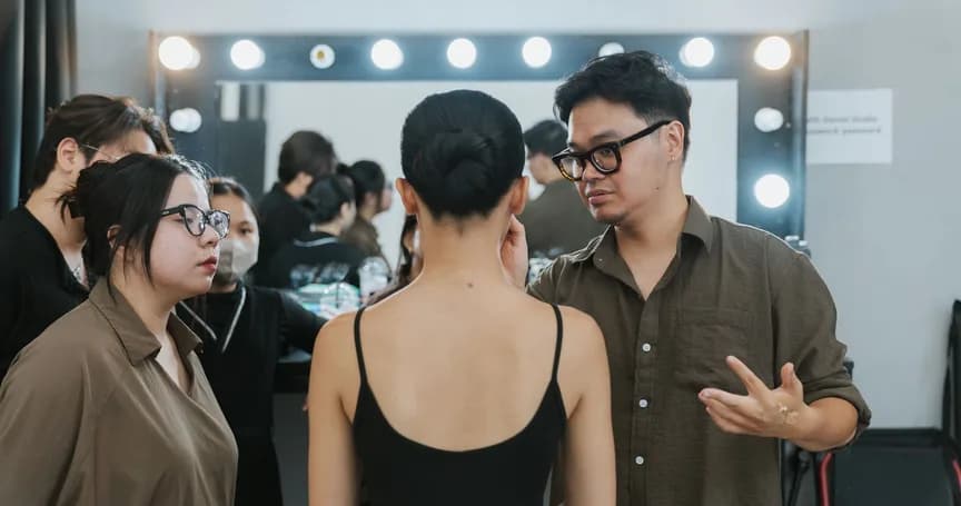 Backstage d'un défilé, mannequins et habilleurs devant les miroirs de loge